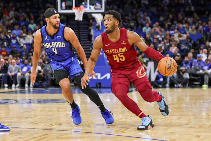 Dec 11, 2023; Orlando, Florida, USA; Cleveland Cavaliers guard Donovan Mitchell (45) drives around Orlando Magic guard Jalen Suggs (4) during the first quarter at Amway Center. Mandatory Credit: Mike Watters-USA TODAY Sports